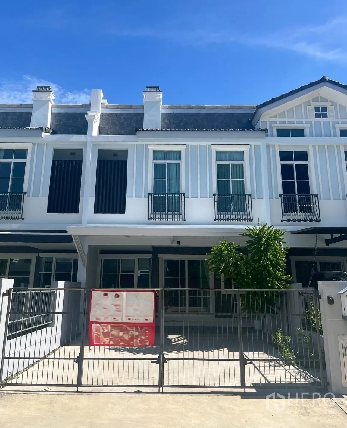 联排别墅 for rent in Prawet, Bangkok - 现代两层联排别墅外立面，带大门与车道。