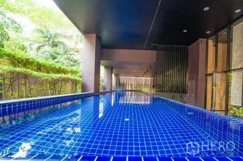 คอนโด ให้เช่าหรือขายในWatthana, Bangkok - สระว่ายน้ำกระเบื้องสีน้ำเงินแบบยาว ใต้หลังคาพร้อมต้นไม้รอบด้าน