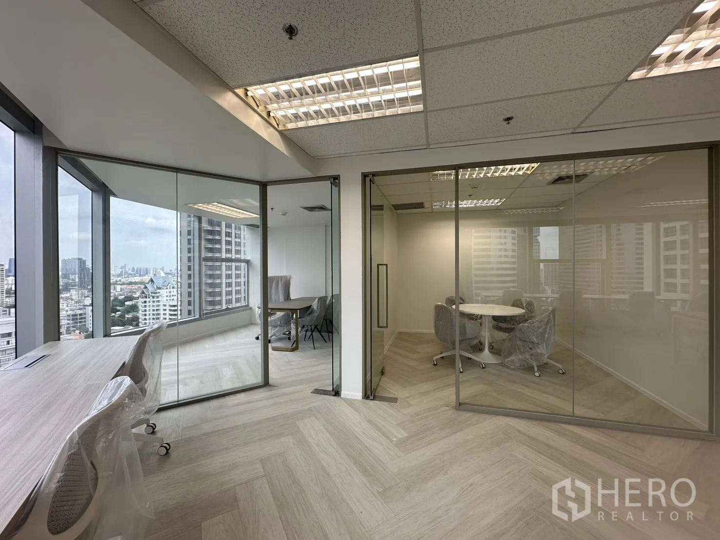 办公室 for rent in Sathon, Bangkok - 两间玻璃隔断会议室，旁边是临窗长桌工位。