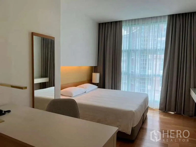 Condominium for rent in Bang Kho Laem, Bangkok - Secondary bedroom with queen bed, desk, and soft natural light.