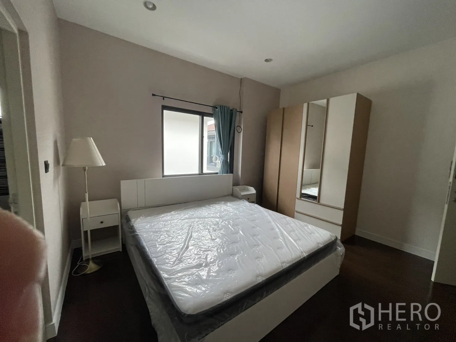 บ้าน ให้เช่าในBang Kapi, Bangkok - ห้องนอนมีเตียง โคมไฟ และตู้ พร้อมประตูเข้าห้องน้ำในตัว