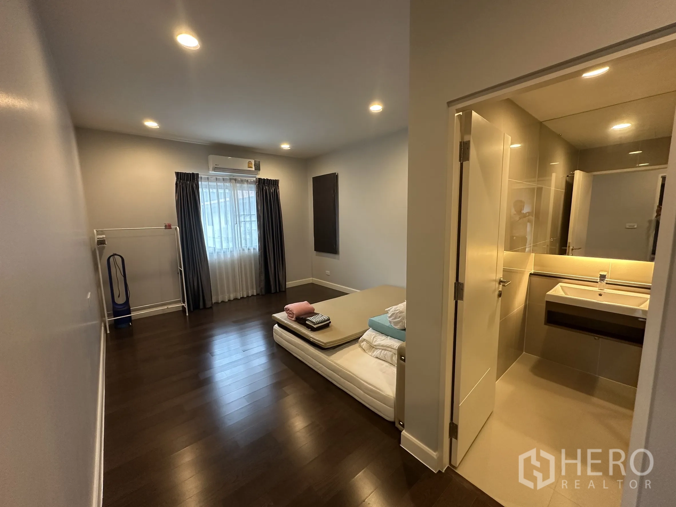 Detached House for rent in Lam Luk Ka, Pathum Thani - Bright bedroom with ensuite access and window draped in curtains.