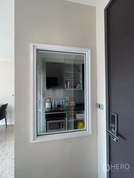 Condominium for sale in Khlong Toei, Bangkok - Kitchen pass-through window by the entrance showing appliances and shelves.