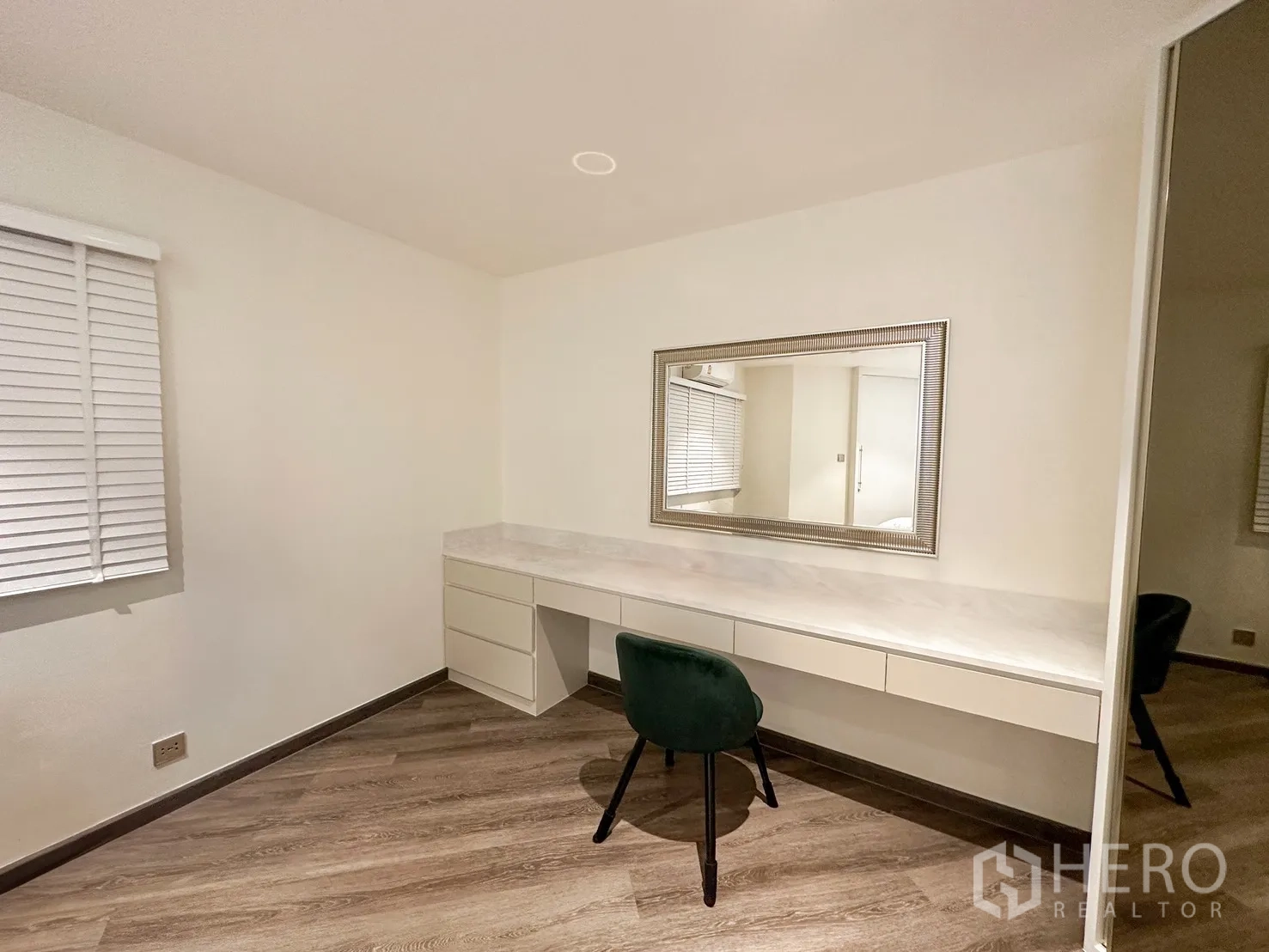 Condominium for rent or sale in Watthana, Bangkok - Bright study or dressing area with long built-in desk, mirror, and window blinds.