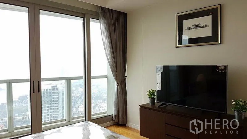 公寓 出租在Khlong San, Bangkok - 卧室配电视柜与推拉玻璃门，外接阳台城市景观