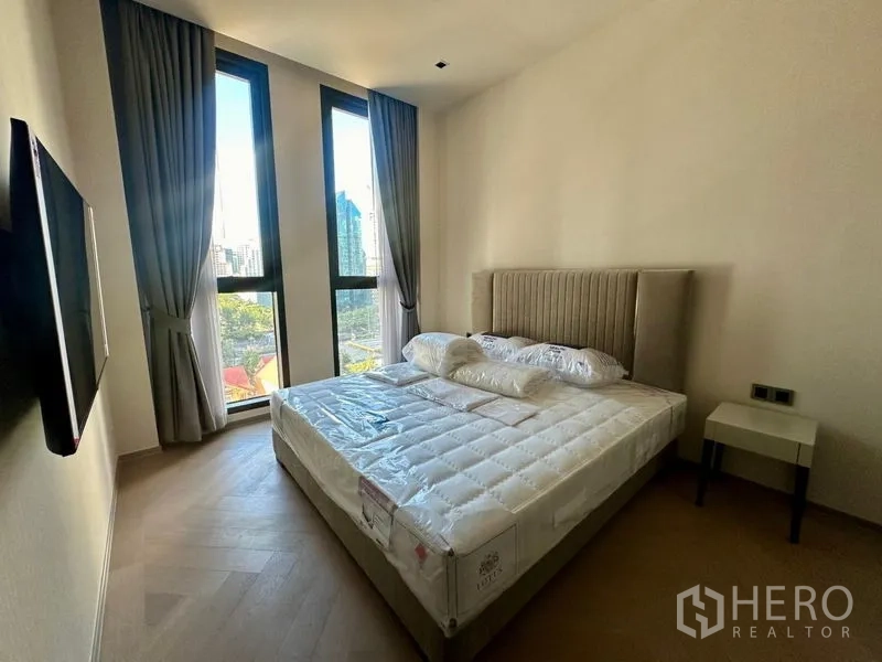 Condominium for rent - Corner bedroom with tall twin windows and skyline view over Sathon.