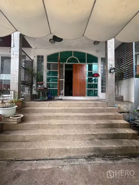 Shophouse for rent in Watthana, Bangkok - Wide front steps leading to an arched glass entrance with solid wooden doors.