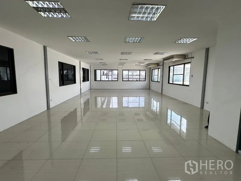 Warehouse for rent in Suan Luang, Bangkok - Spacious office area with multiple windows and ceiling lights.