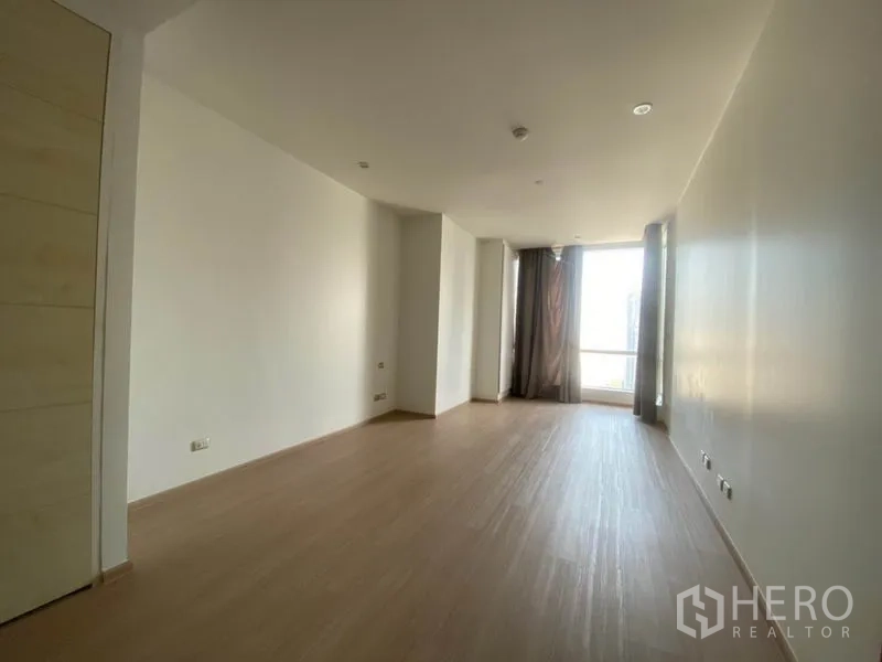 Condominium for rent in Sathon, Bangkok - Bright multipurpose room or second bedroom with light wood flooring and balcony access.