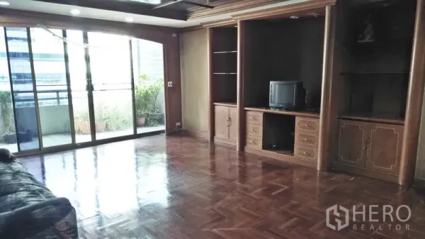 公寓 出售在Watthana, Bangkok - 大型起居室，内置木质柜体，玻璃门通向露台。