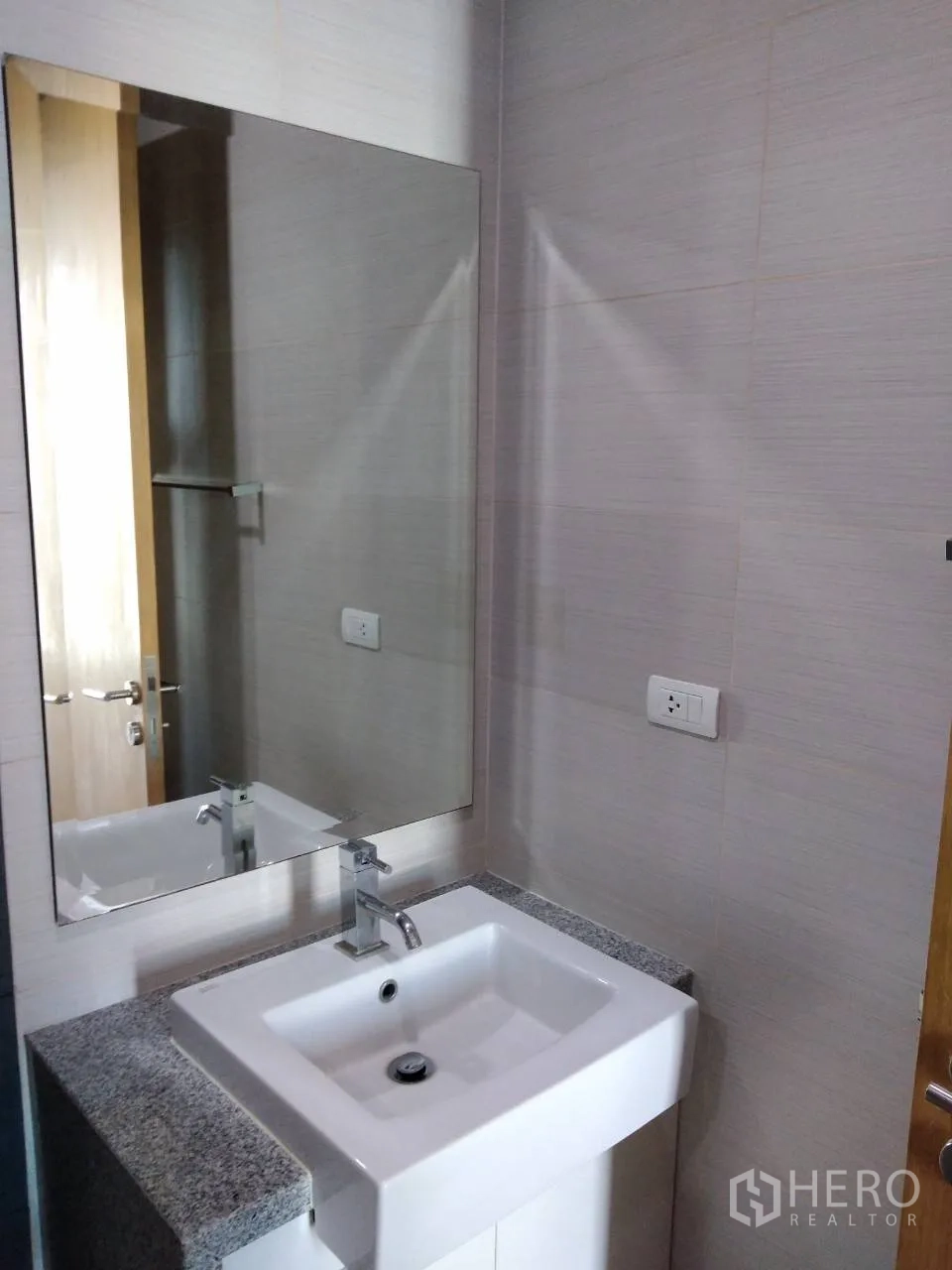 Condominium for rent in Khlong Toei, Bangkok - Second bathroom vanity with large mirror and stone countertop.