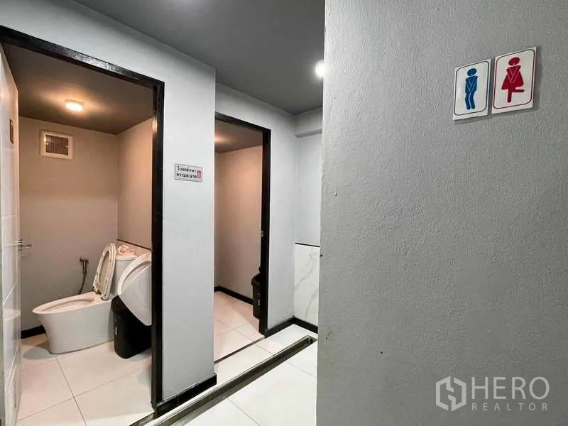 店屋 出租在Lat Phrao, Bangkok - 男女分设公共卫生间，浅色瓷砖装修。