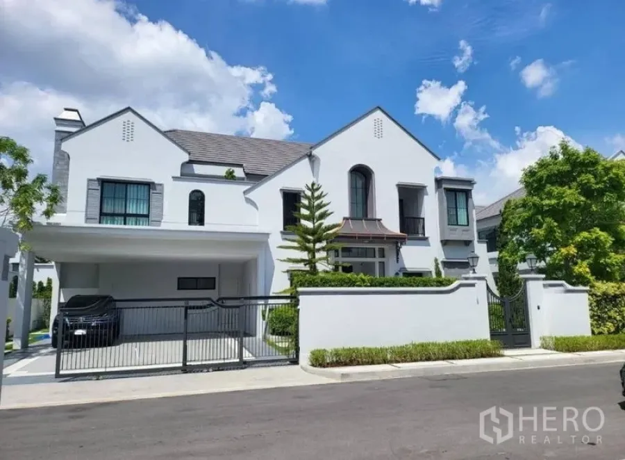 Detached House for rent in Saphan Sung, Bangkok - Front elevation of a modern white detached house with gated driveway.