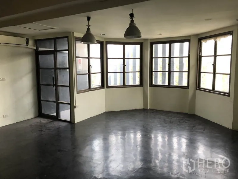 带办公室的家 出租或出售在Huai Khwang, Bangkok - 转角办公室，连排飘窗、吊灯与通阳台的玻璃门。