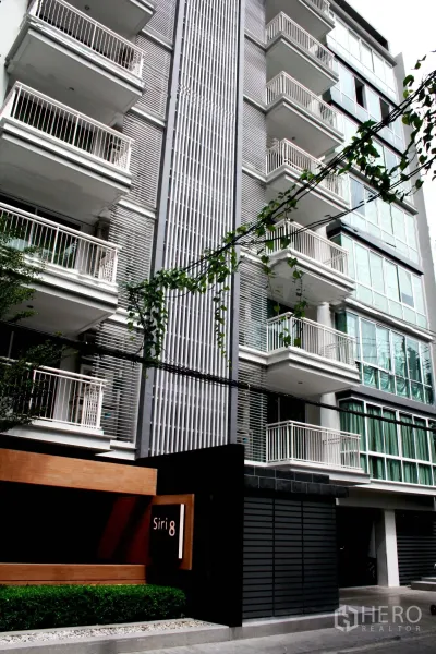 公寓 出租在Khlong Toei, Bangkok - 现代公寓外立面，白色阳台与“Siri 8”入口标识。