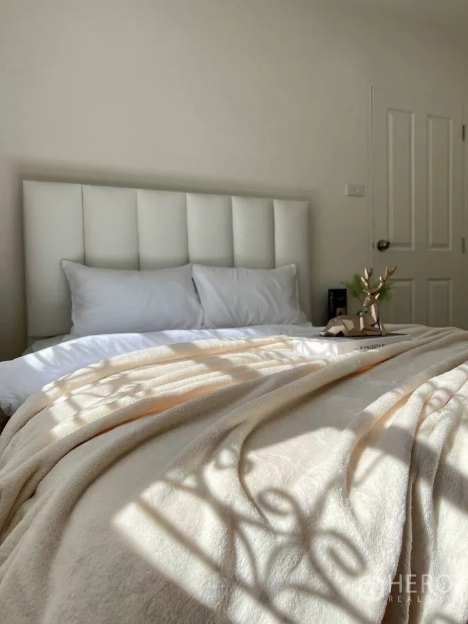 Detached House for rent in Huai Khwang, Bangkok - Cozy bed with plush blanket illuminated by soft morning sunlight.