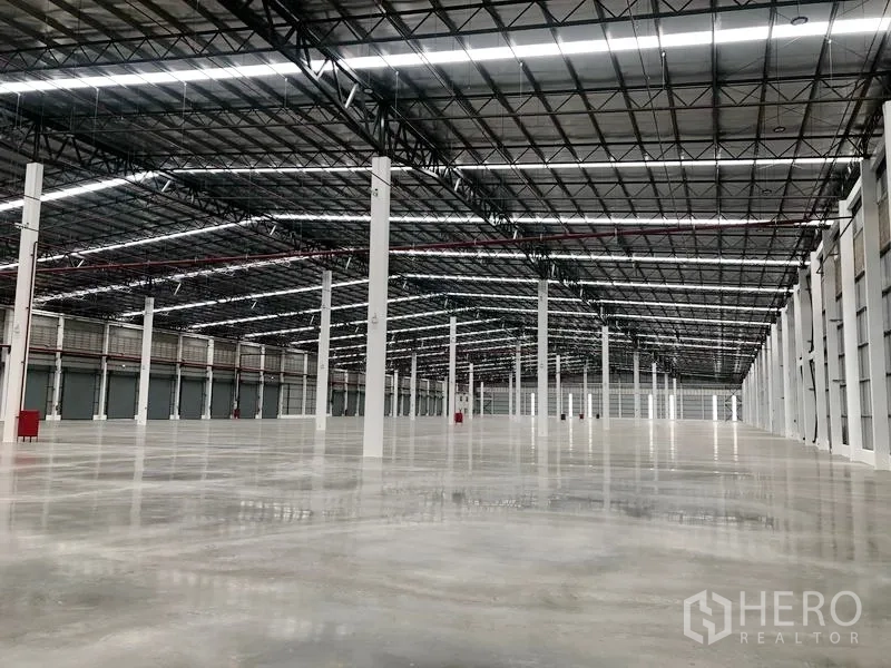 Factory for rent in Wang Noi, Phra Nakhon Si Ayutthaya - Vast warehouse span with tall ceiling, skylight strips, and multiple loading doors.