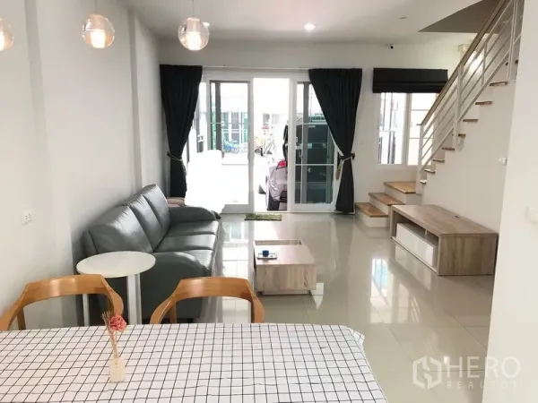 联排别墅 出租或出售在Wang Thonglang, Bangkok - 一层起居区面向车棚与楼梯，整面推拉玻璃门采光充足。