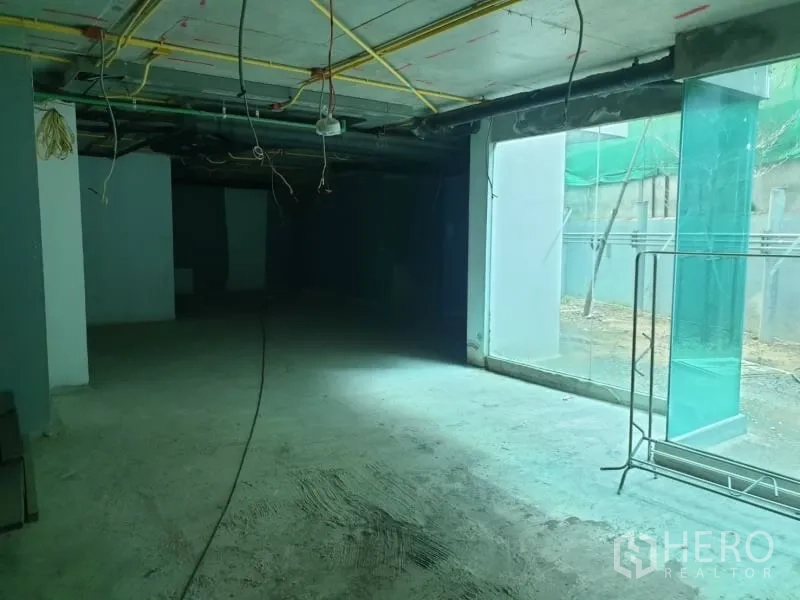 Retail Space for rent in Watthana, Bangkok - Shell-condition retail interior with exposed ceiling services and floor-to-ceiling glass.