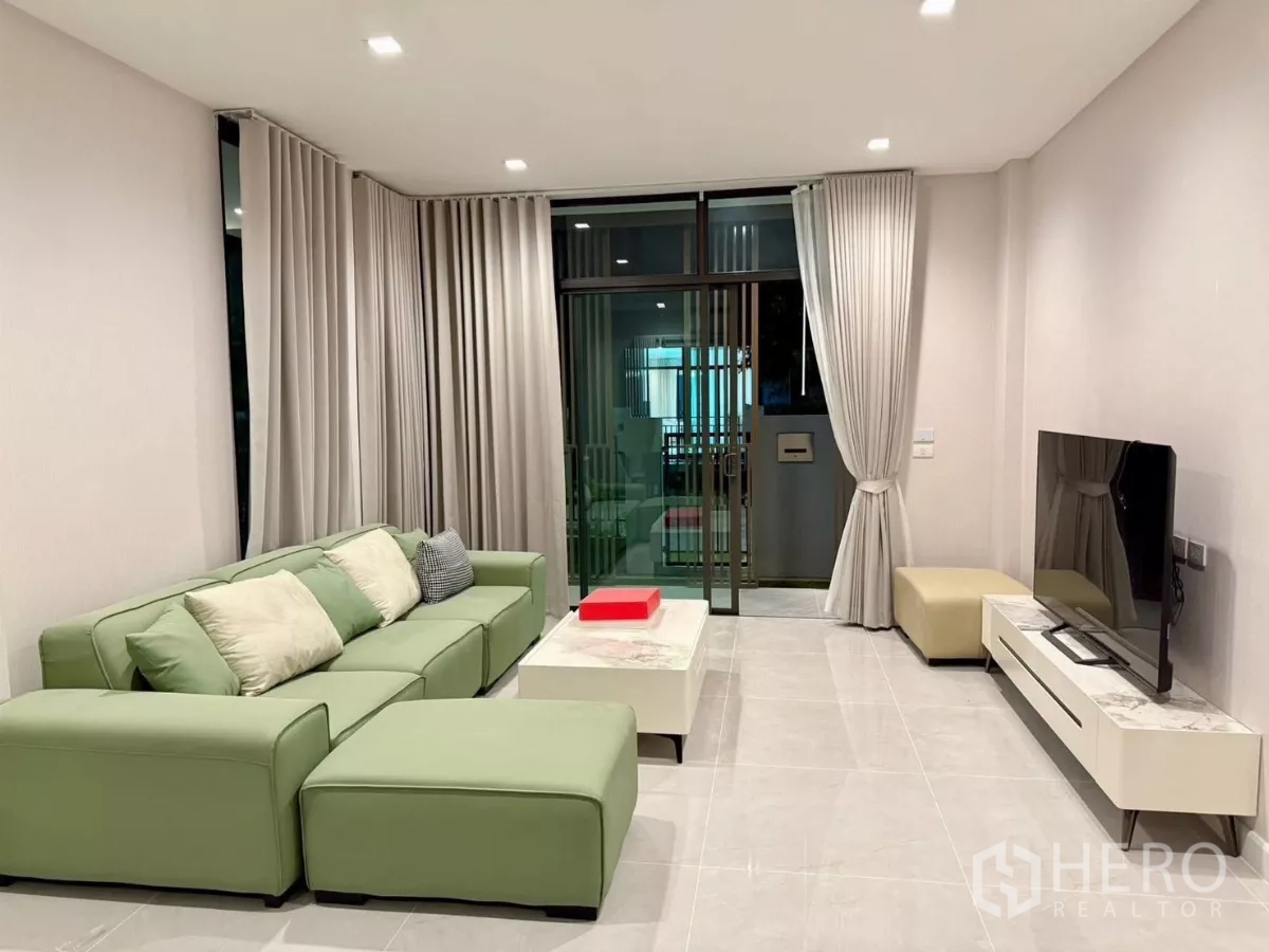 独立式住宅 出租在Bang Phli, Samut Prakan - 客厅设落地窗帘与移门，通向室外露台。