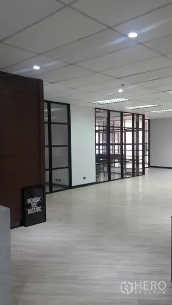 Office Space for rent in Huai Khwang, Bangkok - Open office with light wood flooring and glass-partition meeting rooms under ceiling panels.