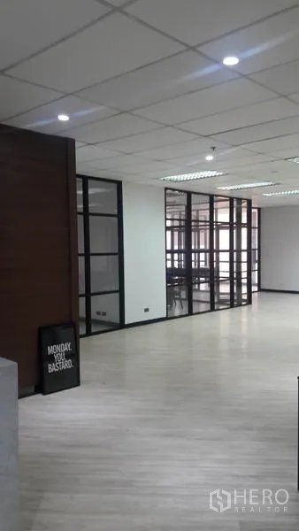 Office Space for rent in Huai Khwang, Bangkok - Open office with light wood flooring and glass-partition meeting rooms under ceiling panels.
