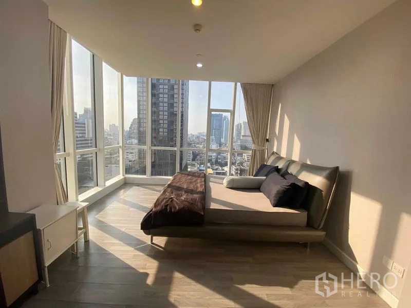 Condominium for rent or sale in Bang Rak, Bangkok - Spacious master bedroom corner with wraparound windows and cityscape views.