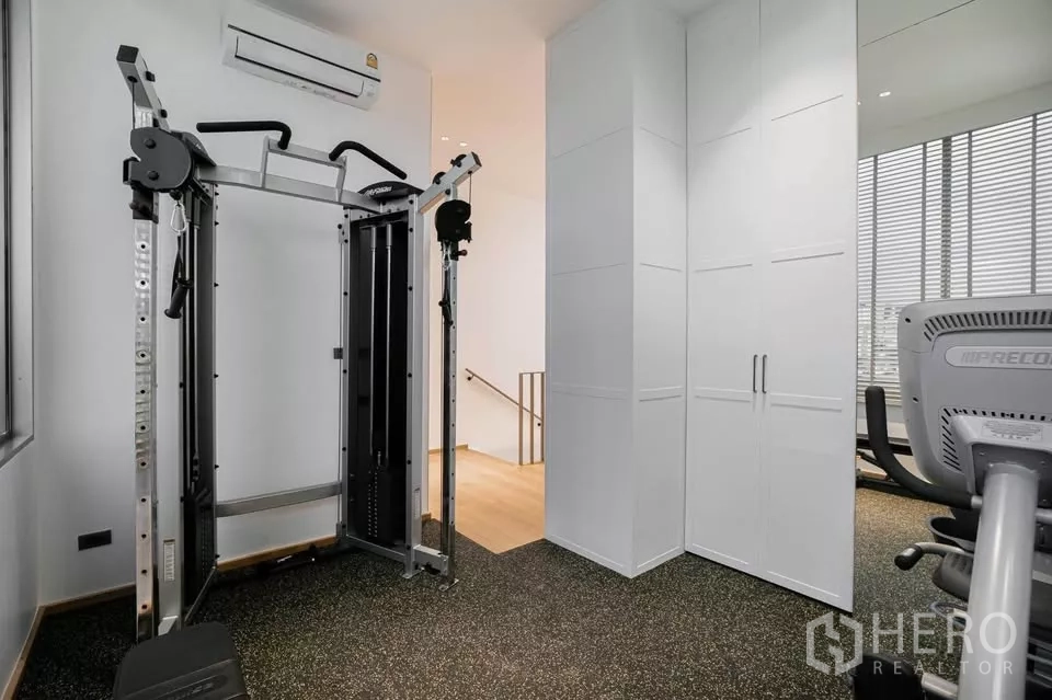 Townhouse for sale in Chatuchak, Bangkok - Private home gym with weight machine and storage cabinets.