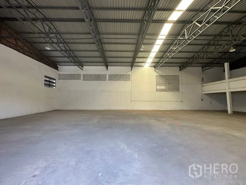 Warehouse for rent in Mueang Pathum Thani, Pathum Thani - Open-plan warehouse floor with tall ceiling, ventilation block windows and long strip lighting.