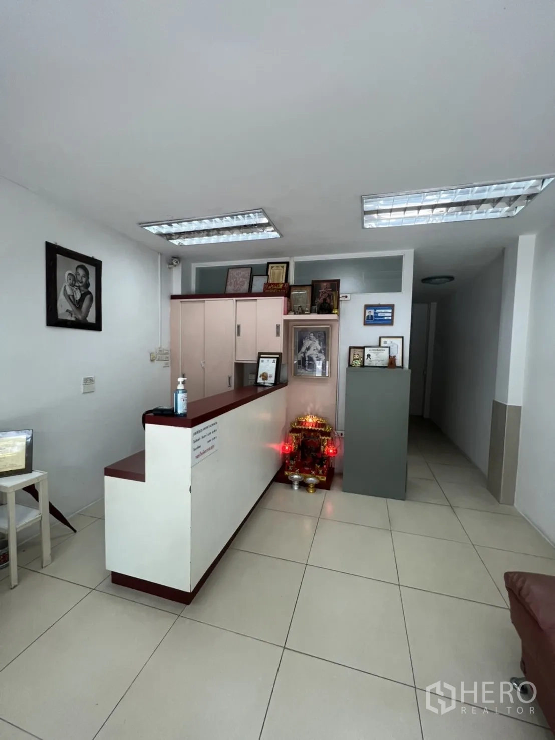 Shophouse for rent in Khlong Toei, Bangkok - Ground-floor reception area with counter, fluorescent ceiling lights and tiled floor.