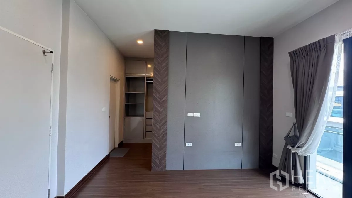 Detached House for rent or sale in Saphan Sung, Bangkok - Bright room with floor‑to‑ceiling drapes, balcony access and a built‑in wardrobe niche.