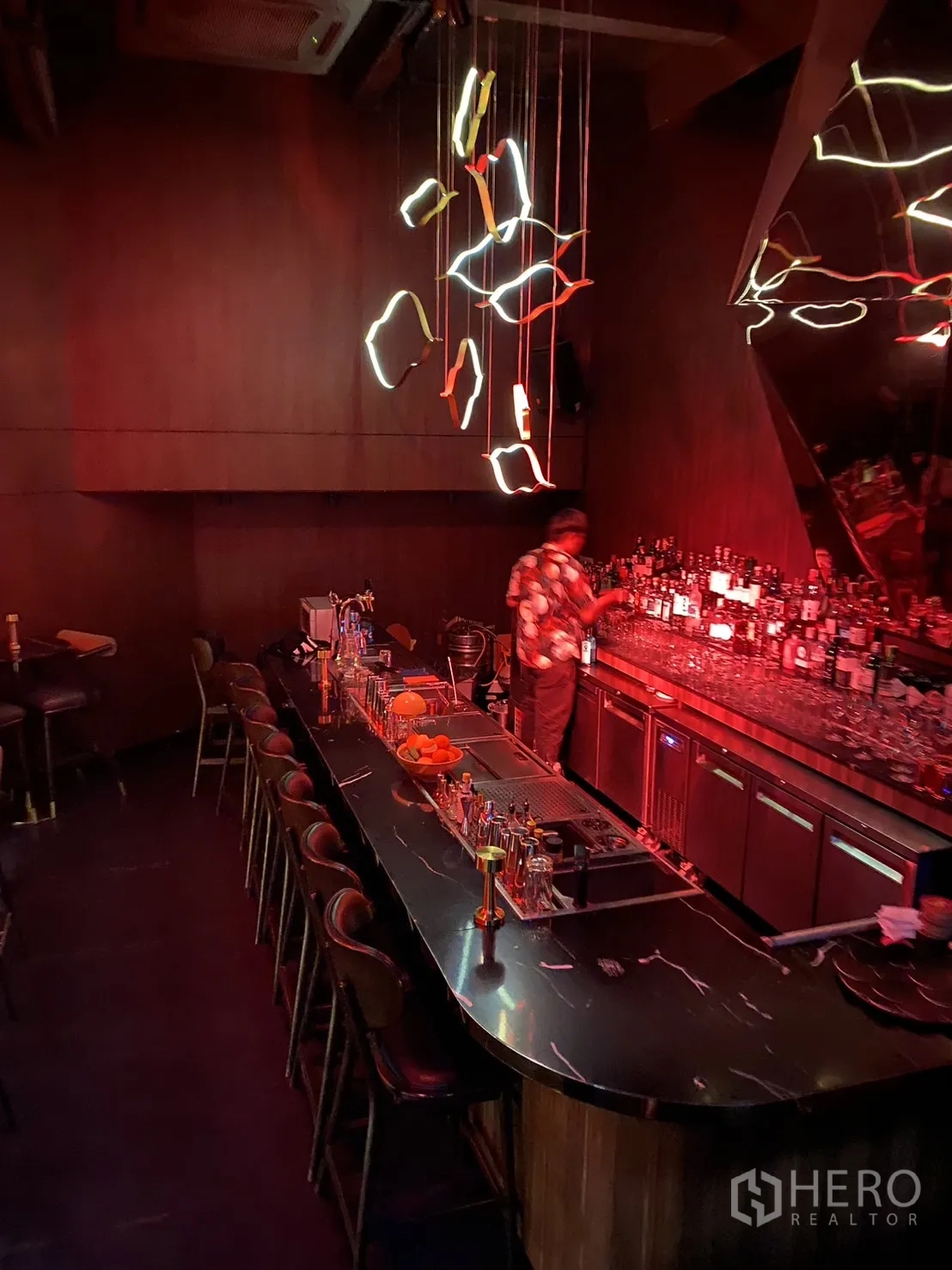 Shophouse for rent in Watthana, Bangkok - Dimly lit bar counter with marble top, back bar shelving and sculptural LED pendants.