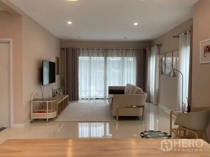 บ้านเดี่ยว for rent in Bang Phli, Samut Prakan - ห้องนั่งเล่นมีทีวี ตู้วางสื่อ และประตูกระจกบานเลื่อน.