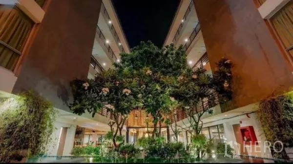 Retail Space for sale in Phra Nakhon, Bangkok - Night view of open-air courtyard with frangipani trees surrounded by multi-storey buildings.