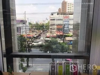 Office Space for rent in Khlong Toei, Bangkok - Urban neighborhood and traffic seen through an interior window frame.