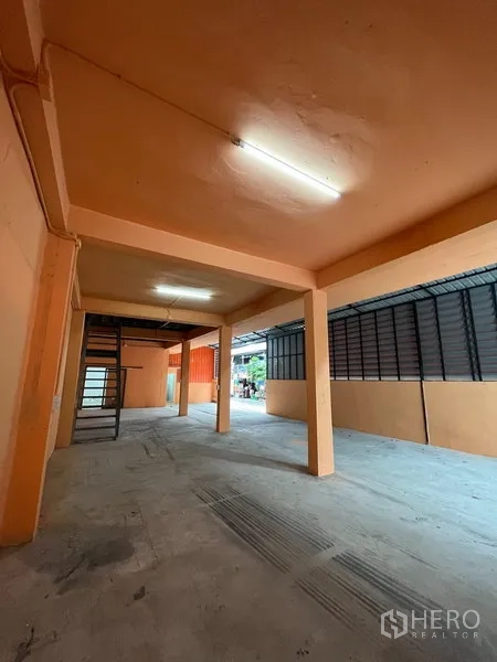คลังสินค้า ให้เช่าในDin Daeng, Bangkok - พื้นที่ชั้นล่างกว้างของโกดัง ไฟนีออน บันไดเหล็กขึ้นชั้นลอย และแผงระบายอากาศด้านข้าง
