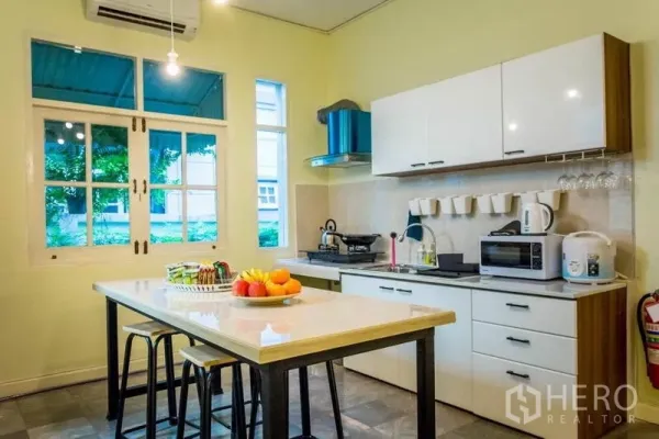 带办公室的家 出租在Suan Luang, Bangkok - 现代厨房，带中岛、白色橱柜与临窗景观。