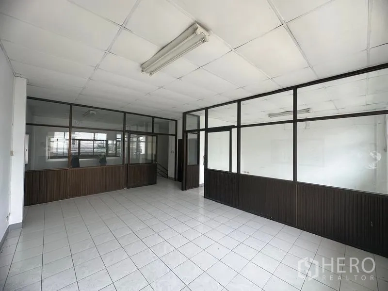 Factory for rent in Khlong Luang, Pathum Thani - Partitioned office room with glass panels and tiled floors inside the factory.