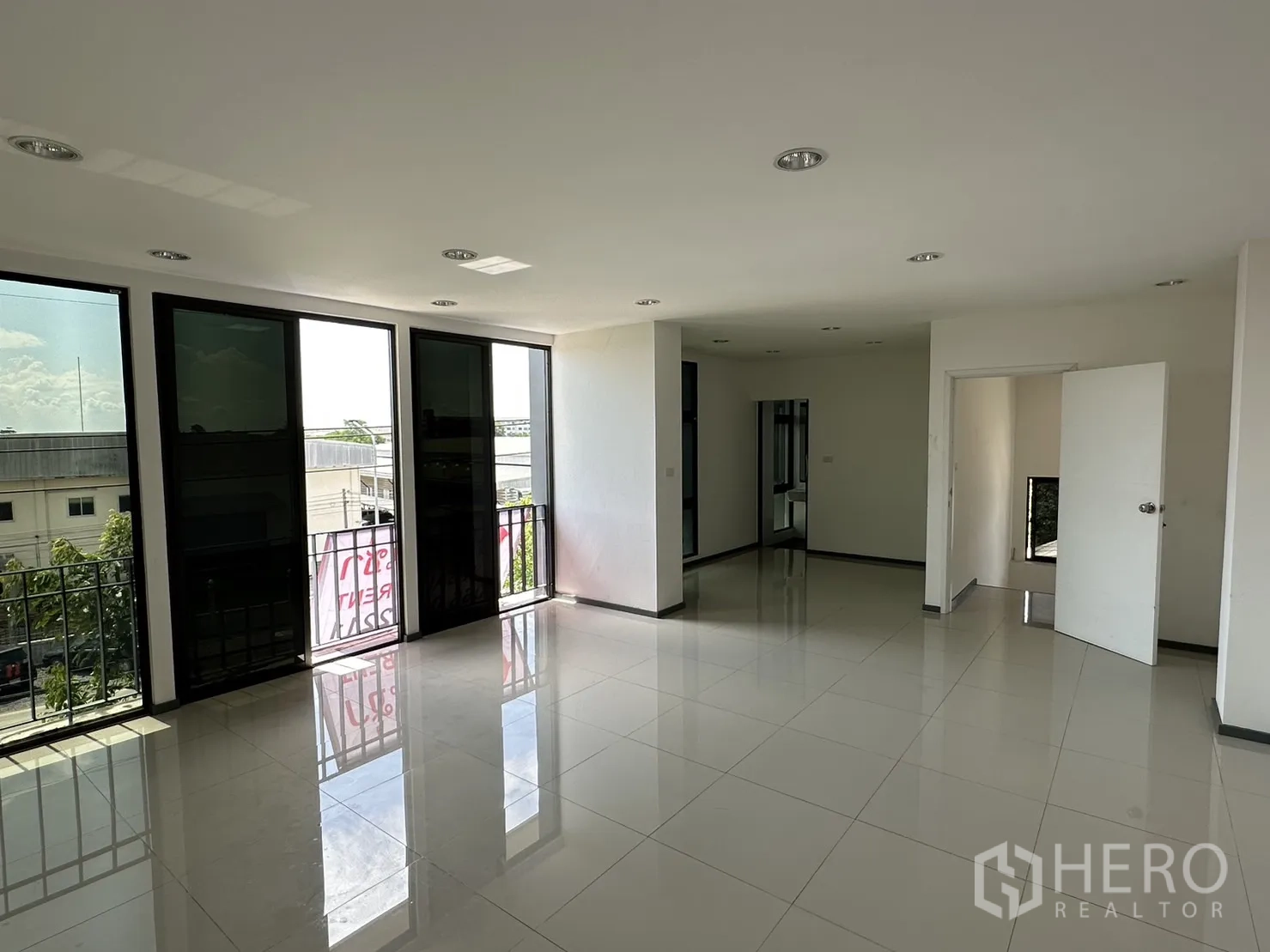 Factory for rent or sale in Pathum Thani - Top-floor open office with balcony doors and city views.