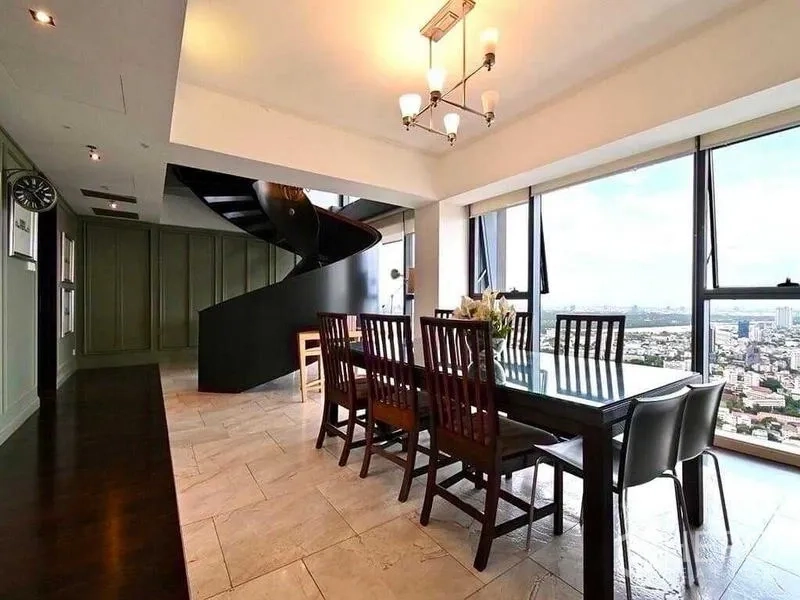 Condominium for rent - Eight-seat dining beside windows, near sculptural black spiral staircase.