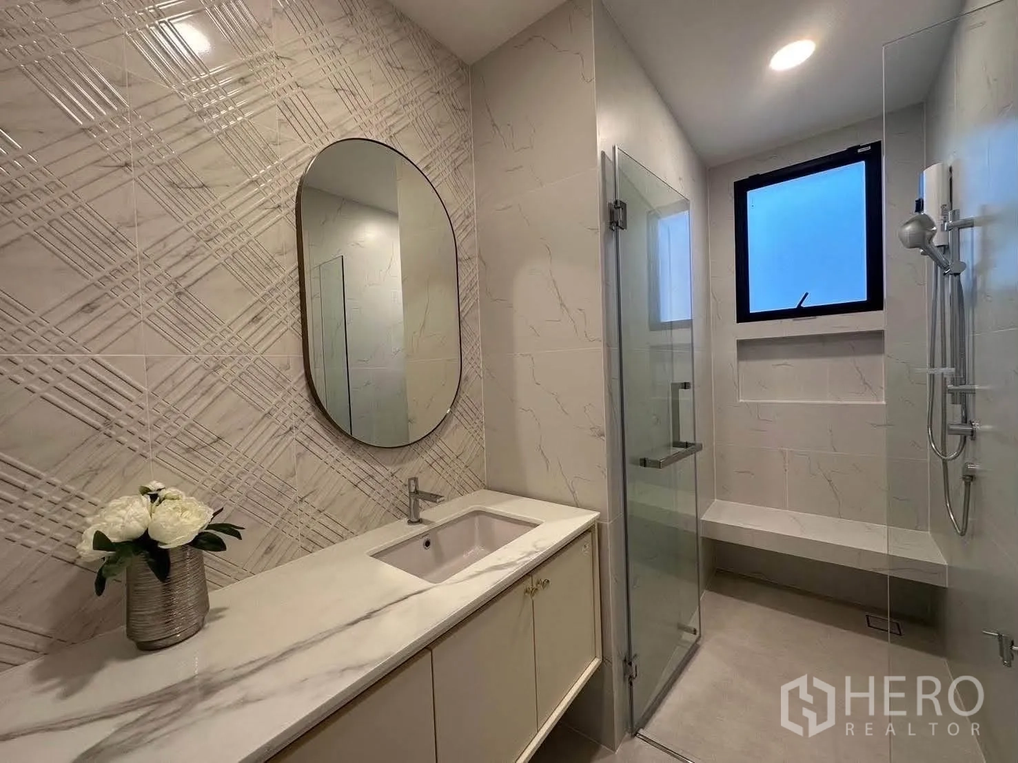 Detached House for rent in Saphan Sung, Bangkok - Modern bathroom with long vanity and glass-enclosed shower with bench.