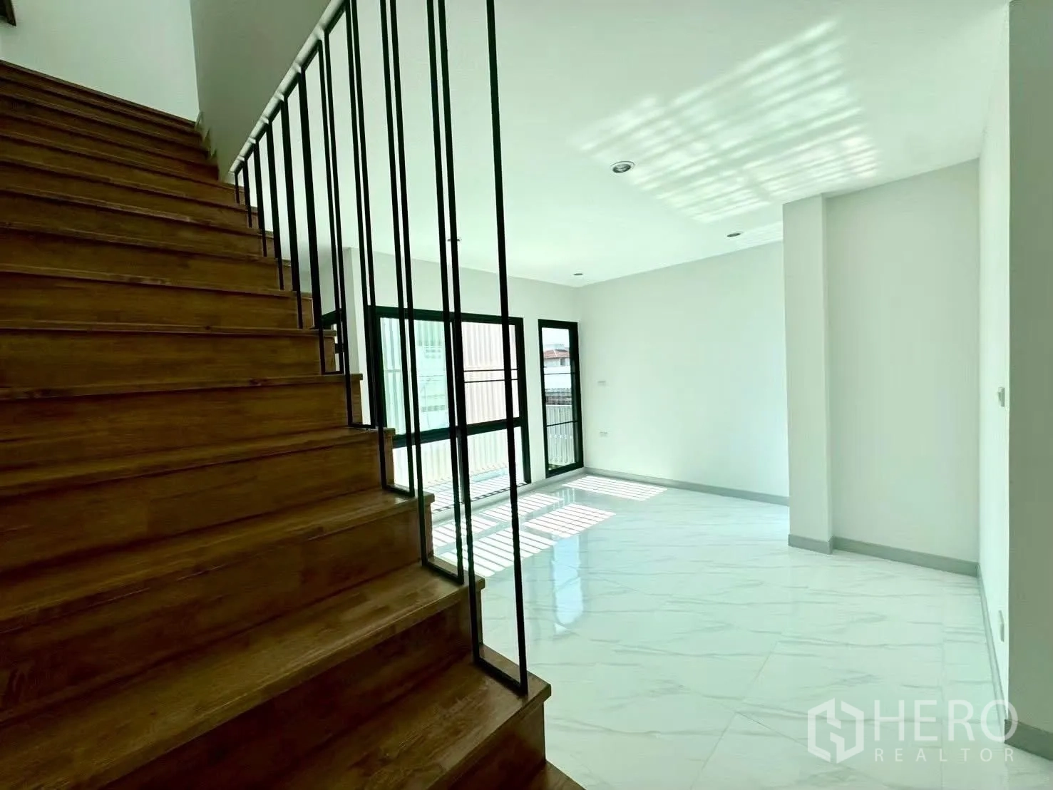 家庭办公室 for rent in Wang Thonglang, Bangkok - 木质踏步与金属扶手的楼梯，旁为采光良好的起居区。