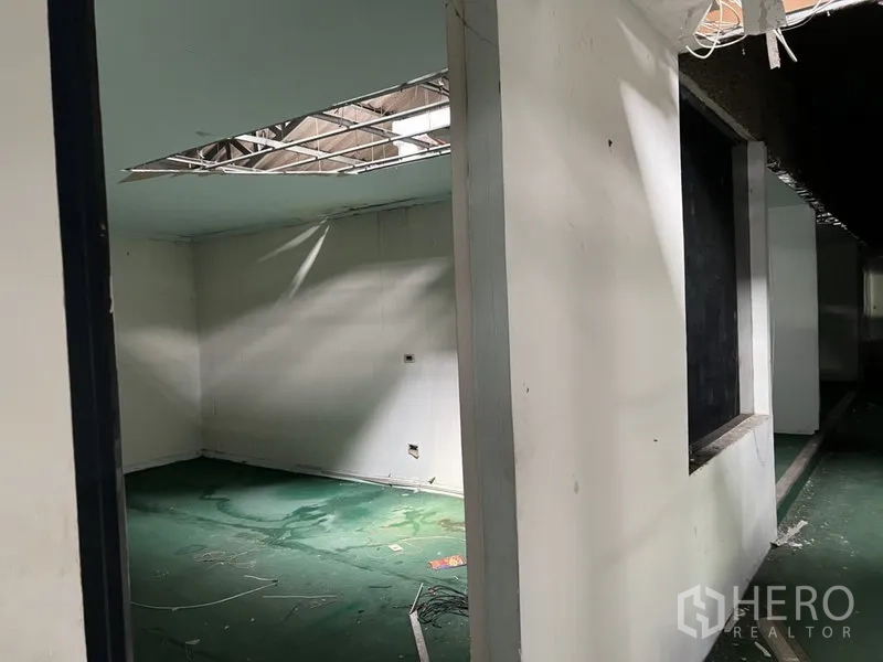 Warehouse for rent in Bang Kapi, Bangkok - Corner office room with window opening and partial ceiling removal in the warehouse.