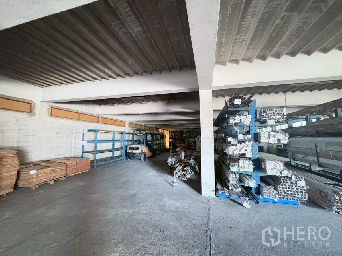 工厂 出租或出售在Bang Khun Thian, Bangkok - 仓库通道，配叉车、货架和堆放的材料。