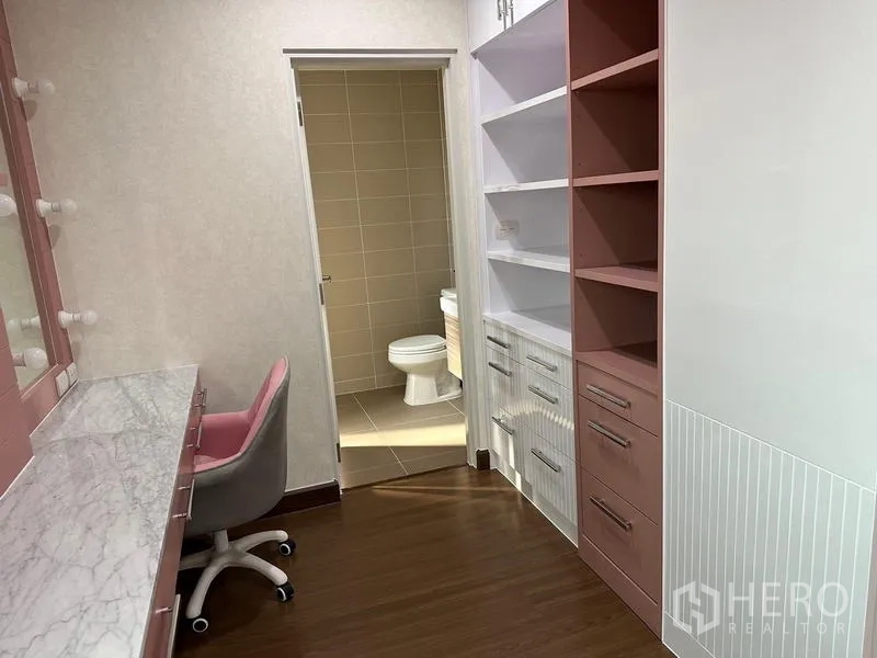 Detached House for sale in Saphan Sung, Bangkok - Dressing area with marble vanity and built-in shelves leading to an ensuite bathroom.