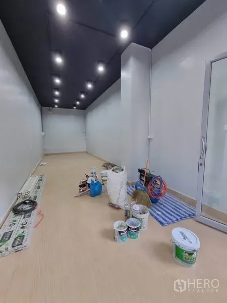 Retail Space for rent in Khlong Toei, Bangkok - 35 sqm retail unit interior with white walls, dark ceiling and rows of LED downlights, glass entry during fit-out.