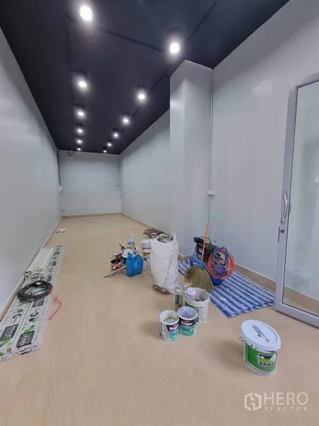 Retail Space for rent in Khlong Toei, Bangkok - 35 sqm retail unit interior with white walls, dark ceiling and rows of LED downlights, glass entry during fit-out.