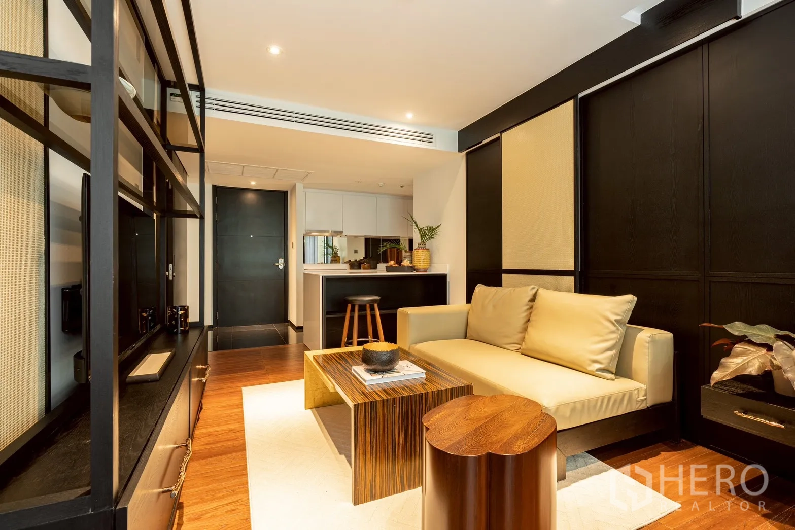 คอนโด for rent or sale in Pathum Wan, Bangkok - ห้องนั่งเล่นเชื่อมครัวแบบเปิดและผนังชั้นวางทีวีดีไซน์โมเดิร์น