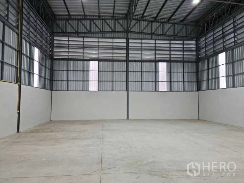 คลังสินค้า ให้เช่าในBang Bua Thong, Nonthaburi - ด้านหน้าโครงการ มีลานจอดรถ รถตู้และรถกระบะหน้าตัวอาคารเมทัลชีทใหม่