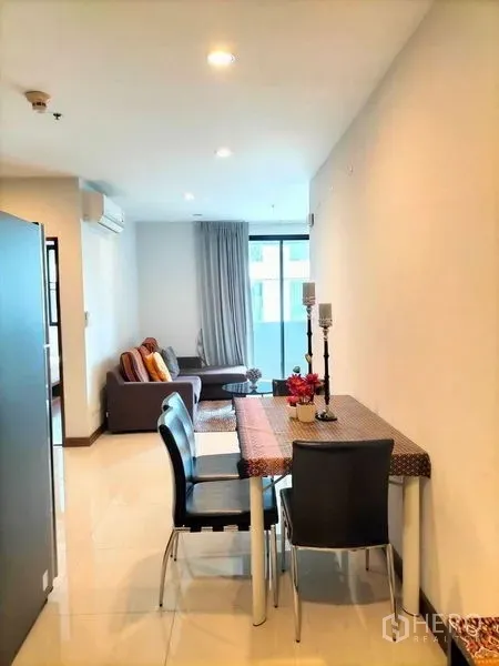 Condominium for rent in Watthana, Bangkok - Open-plan dining area leading to a cozy living room with balcony access in a modern Bangkok condo.